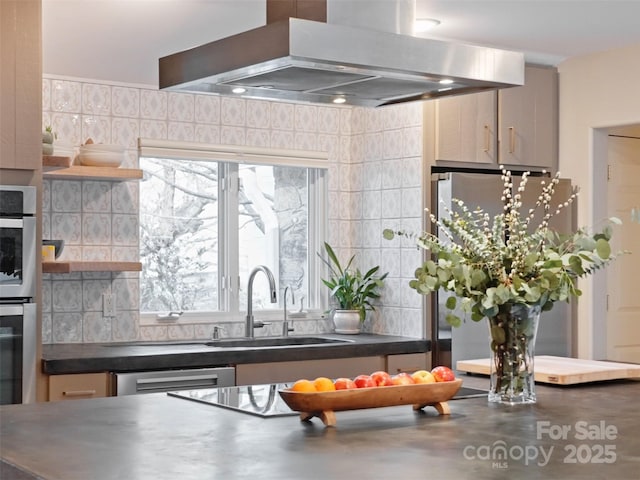 kitchen featuring dark countertops, appliances with stainless steel finishes, a sink, extractor fan, and backsplash