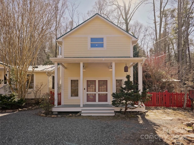 view of front facade with covered porch and fence