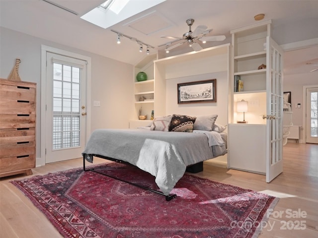 bedroom featuring rail lighting and wood finished floors