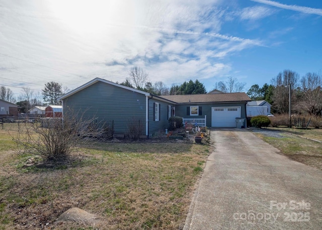 single story home with a garage, fence, a front lawn, and concrete driveway