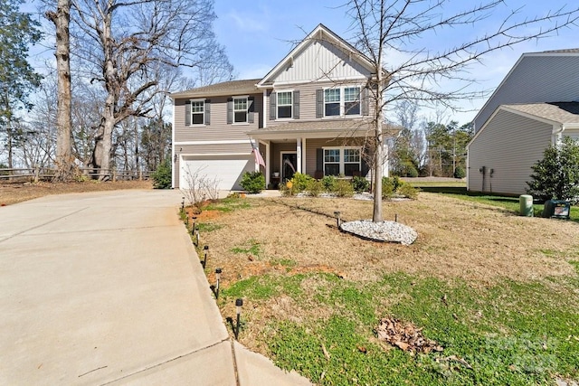 craftsman-style home featuring an attached garage, a front lawn, board and batten siding, and concrete driveway