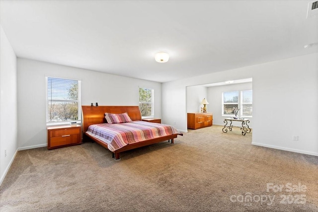 bedroom with light carpet, multiple windows, and baseboards