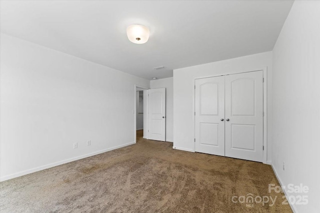 unfurnished bedroom featuring carpet floors, a closet, and baseboards