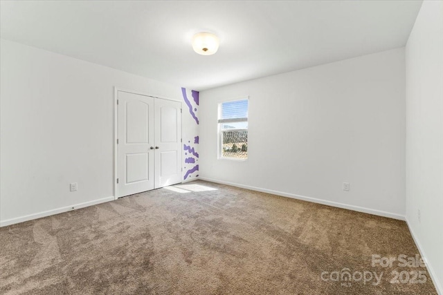 unfurnished bedroom featuring a closet, carpet flooring, and baseboards