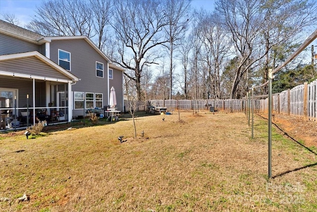 view of yard featuring a fenced backyard and a sunroom