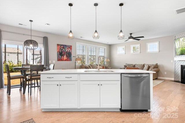 kitchen with open floor plan, visible vents, a sink, and stainless steel dishwasher