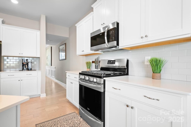 kitchen featuring white cabinets, stainless steel appliances, and light countertops