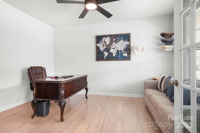 home office with a ceiling fan, baseboards, wood finished floors, and french doors