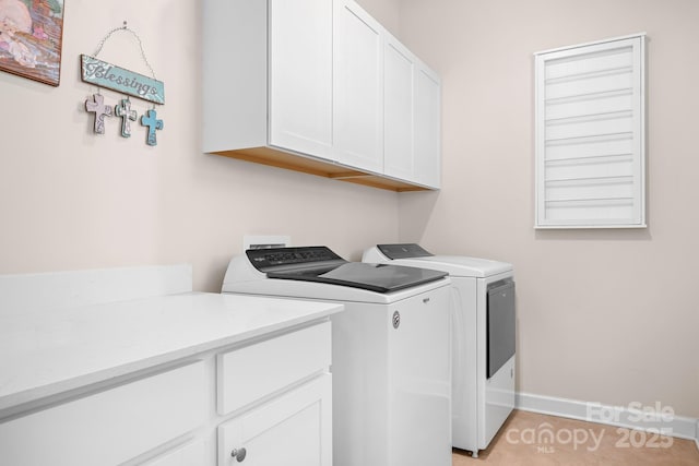 washroom with cabinet space, independent washer and dryer, and baseboards