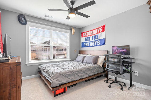 carpeted bedroom featuring a ceiling fan, visible vents, and baseboards