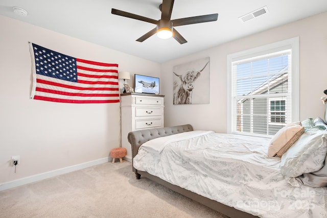 bedroom with baseboards, visible vents, ceiling fan, and light colored carpet