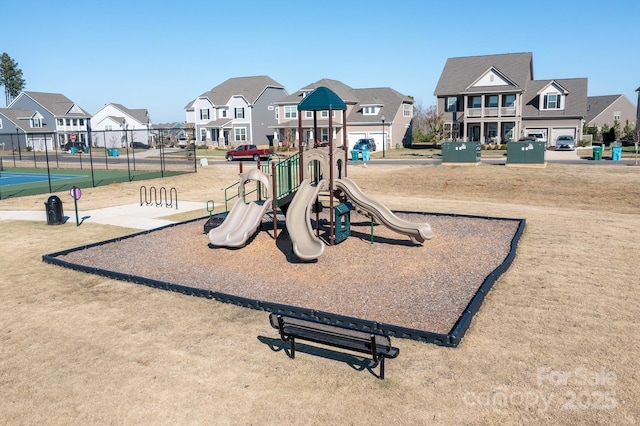 communal playground featuring fence and a residential view