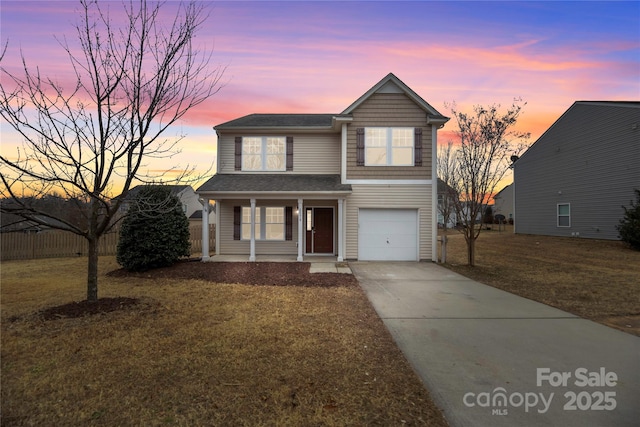 traditional-style home featuring a front yard, driveway, and an attached garage