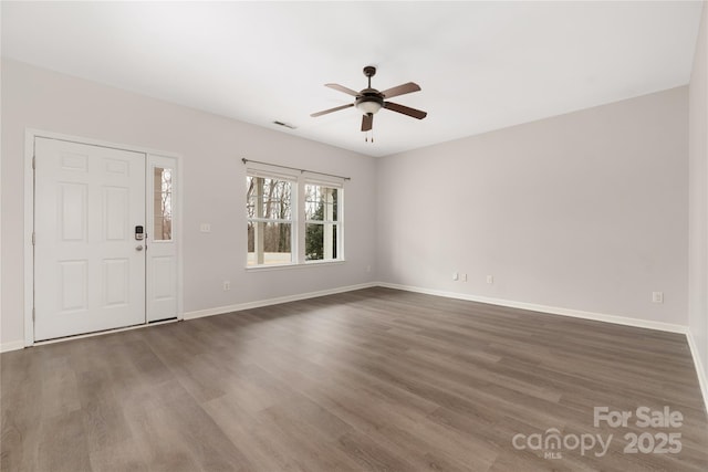 interior space with visible vents, wood finished floors, a ceiling fan, and baseboards