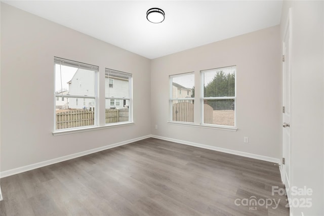 empty room with baseboards and wood finished floors