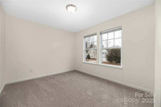 empty room featuring carpet floors and baseboards