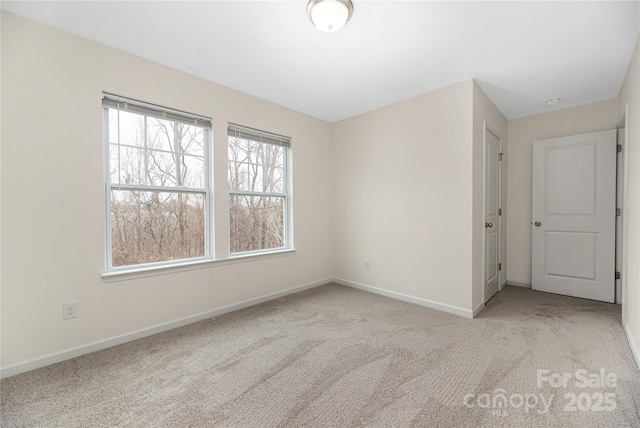 empty room with carpet and baseboards