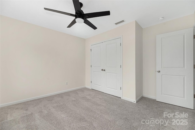 unfurnished bedroom featuring carpet, a closet, visible vents, and baseboards