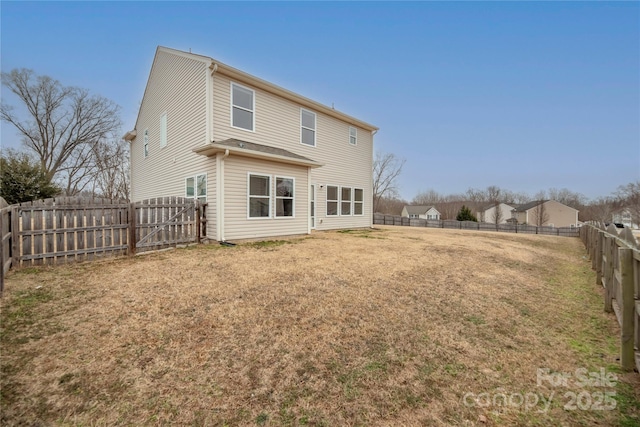 rear view of property with a lawn and a fenced backyard