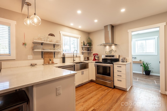 kitchen with wall chimney exhaust hood, stainless steel electric stove, light wood-style floors, open shelves, and a sink