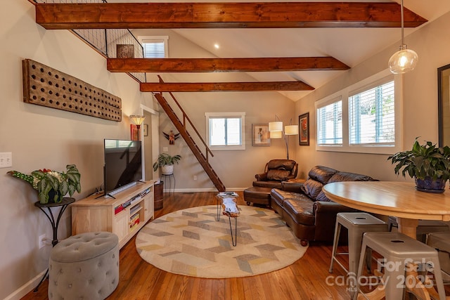 living room with vaulted ceiling with beams, baseboards, and wood finished floors