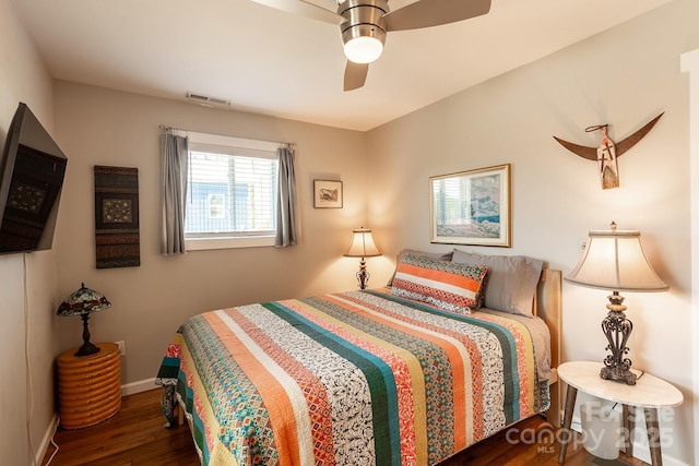 bedroom with a ceiling fan, baseboards, visible vents, and wood finished floors