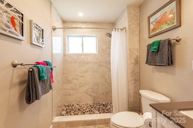 full bath with a stall shower, vanity, and toilet