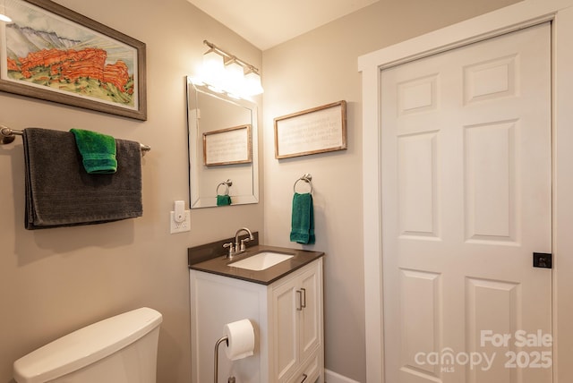 half bathroom featuring toilet and vanity