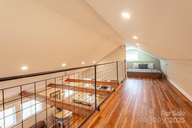 bonus room with wood-type flooring, baseboards, and vaulted ceiling