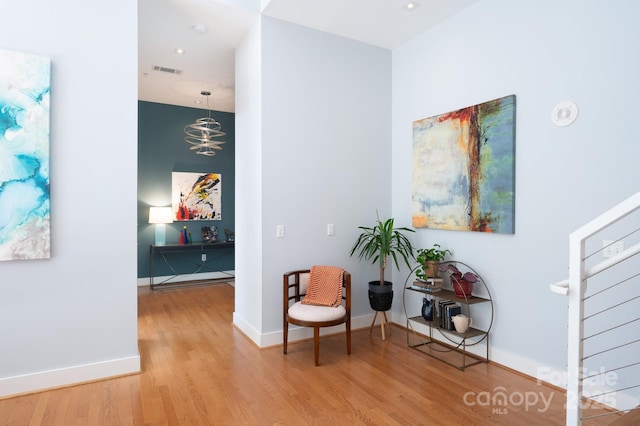 living area featuring visible vents, baseboards, and wood finished floors