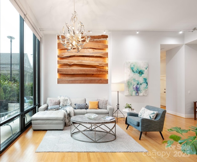 living room featuring a healthy amount of sunlight, wood finished floors, and floor to ceiling windows