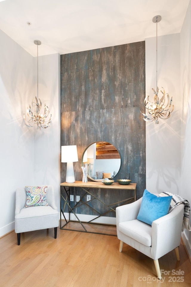 sitting room featuring a chandelier and wood finished floors