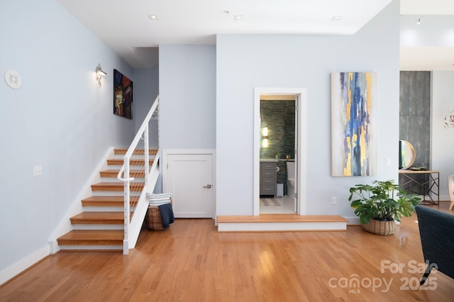 staircase with baseboards and wood finished floors