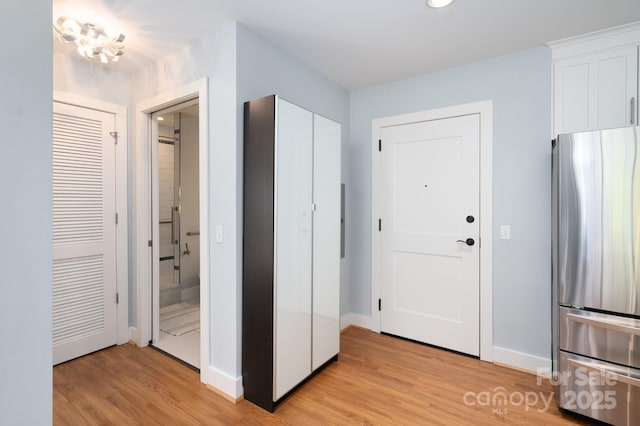 interior space featuring baseboards and light wood finished floors