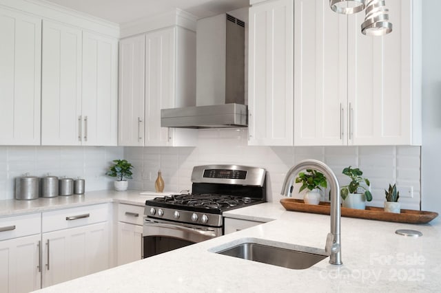 kitchen featuring wall chimney exhaust hood, gas stove, backsplash, and a sink