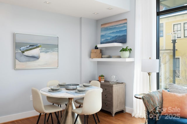 dining space with wood finished floors and baseboards