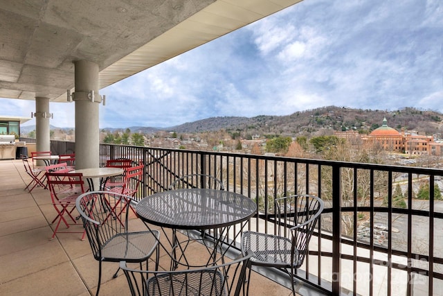 balcony featuring a mountain view and outdoor dining space