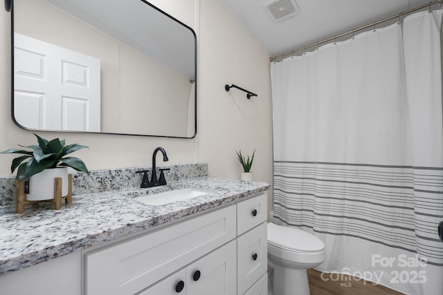 bathroom featuring toilet, a shower with curtain, visible vents, and vanity