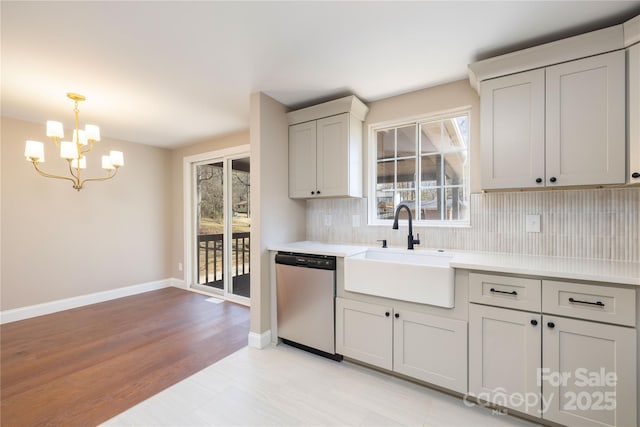 kitchen with a sink, a wealth of natural light, tasteful backsplash, and dishwasher