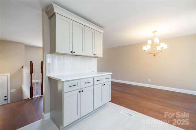 kitchen featuring an inviting chandelier, light wood-style flooring, visible vents, and light countertops