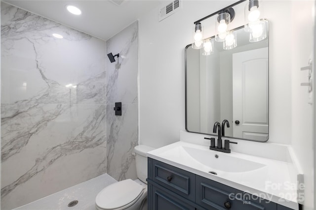 full bath with a marble finish shower, recessed lighting, visible vents, toilet, and vanity