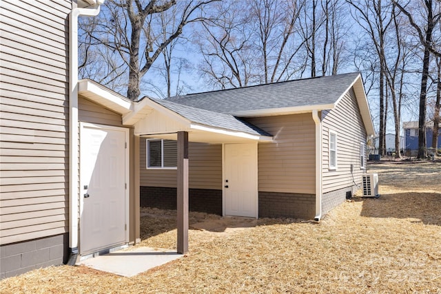 view of property exterior with roof with shingles, crawl space, and ac unit