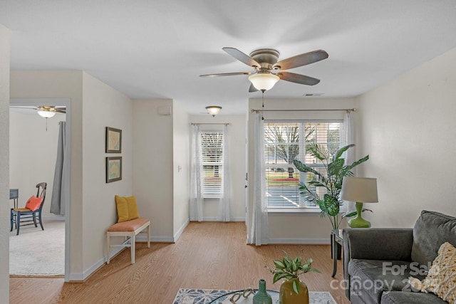 interior space featuring light wood-style floors, visible vents, baseboards, and a ceiling fan