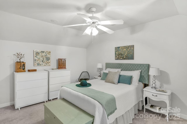 bedroom featuring lofted ceiling, light carpet, and baseboards