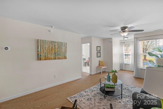 living area with visible vents, baseboards, and wood finished floors