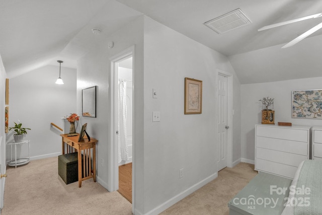 bedroom featuring lofted ceiling, baseboards, visible vents, and light colored carpet