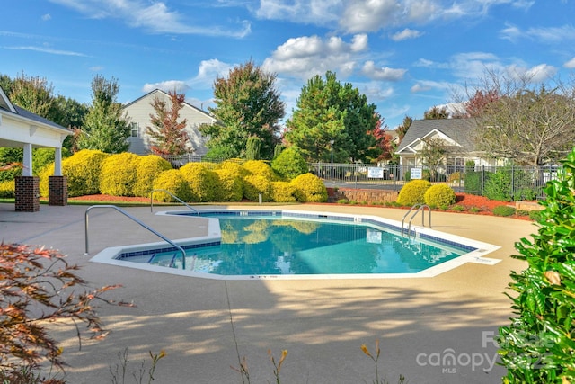 pool featuring fence and a patio