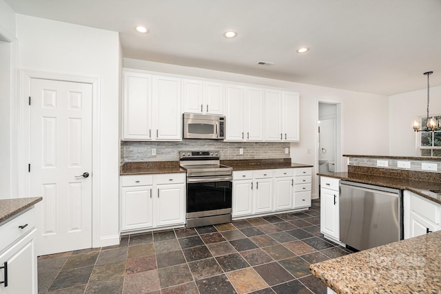 kitchen featuring stainless steel appliances, recessed lighting, a notable chandelier, and decorative backsplash