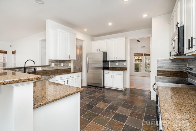 kitchen featuring appliances with stainless steel finishes, stone counters, white cabinetry, and recessed lighting