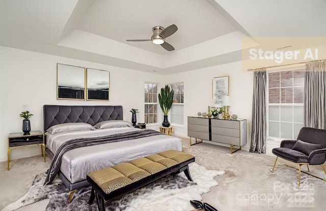 bedroom featuring light carpet, a tray ceiling, and a ceiling fan